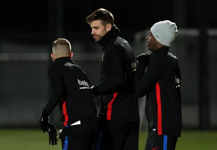 El delantero francés del FC Barcelona, Ousmane Dembélé (d), junto a su compañero Gerard Piqué (c) durante el entrenamiento que realiza la plantilla barcelonista / EFE