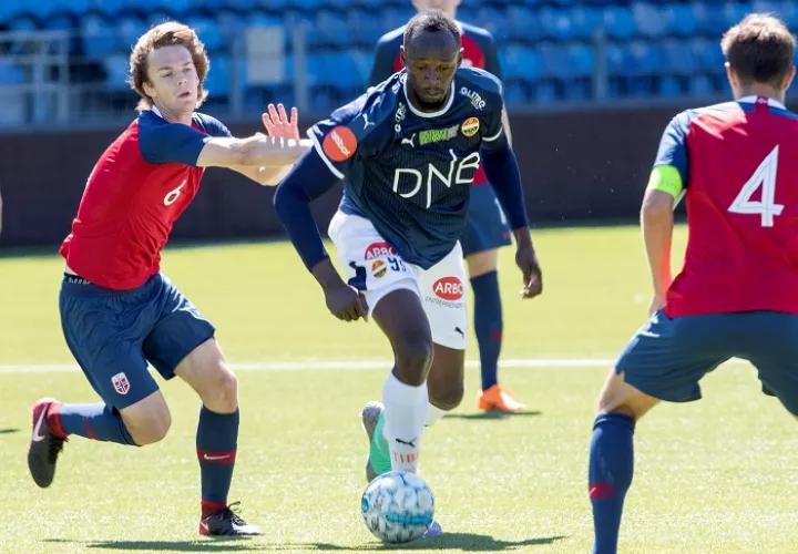 El exatleta jamaicano Usain Bolt (d) disputa un balón con el jugador de la selección noruega sub&#039;19./EFE