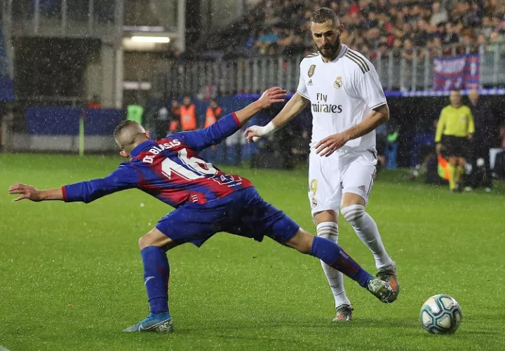  El delantero francés del Real Madrid Karim Benzema (d) disputa un balón con Pablo De Blasis. Foto: EFE