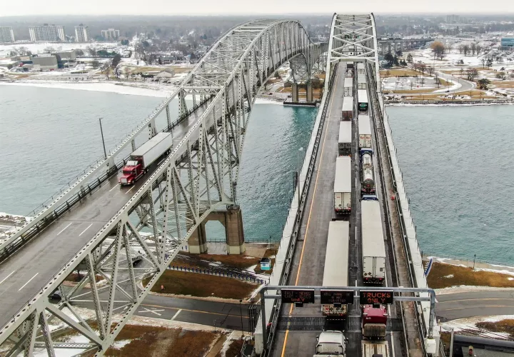 Una foto aérea hecha con un dron muestra camiones (d) que entran en Canadá respaldados en el Puente de Agua Azul sobre el río St. Clair que une los Estados Unidos y Canadá.