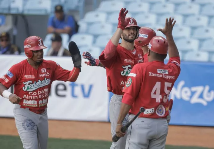 Michael Wielansky (i) es felicitado luego de conectar un cuadrangular de dos carreras para ayudar al triunfo de los Federales. Foto: Serie del Caribe