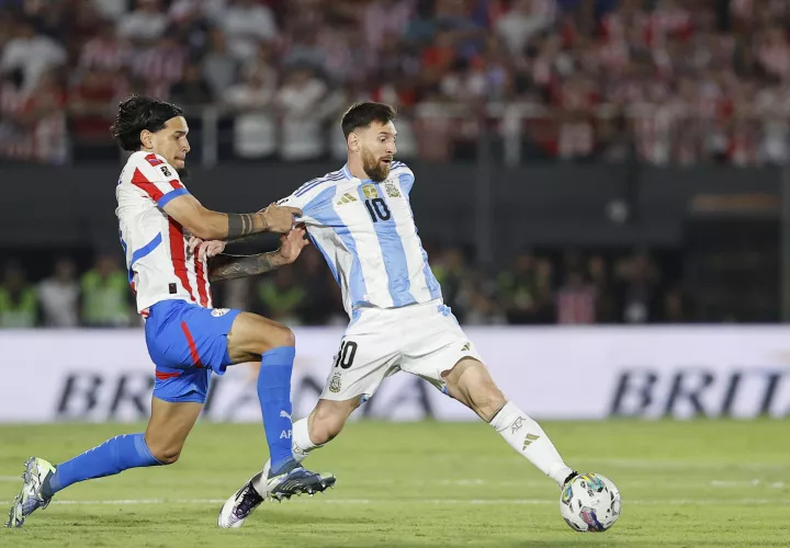 Thiago Almada (i) de Paraguay disputa un balón con Lionel Messi de Argentina. /Foto: EFE